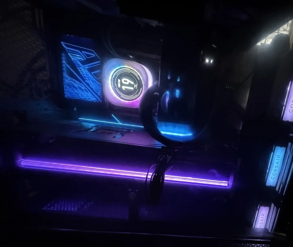 My personal PC build with blue and purple lighting behind a glass side panel.